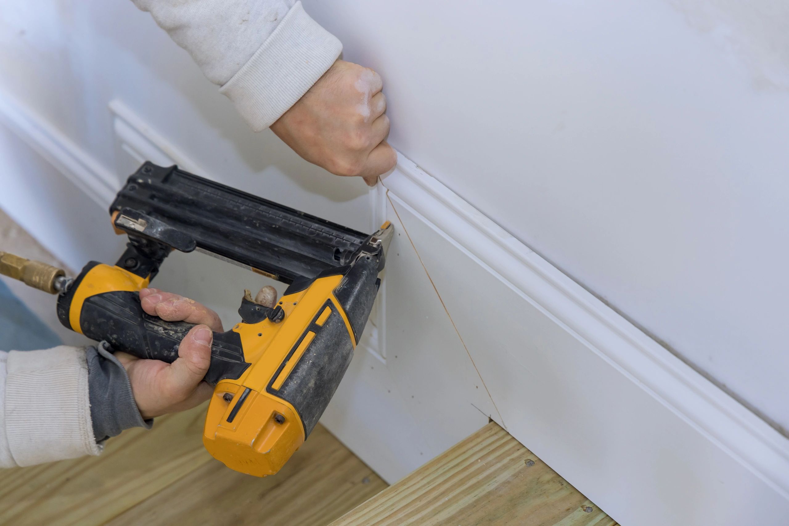 Carpenter installing base molding trim