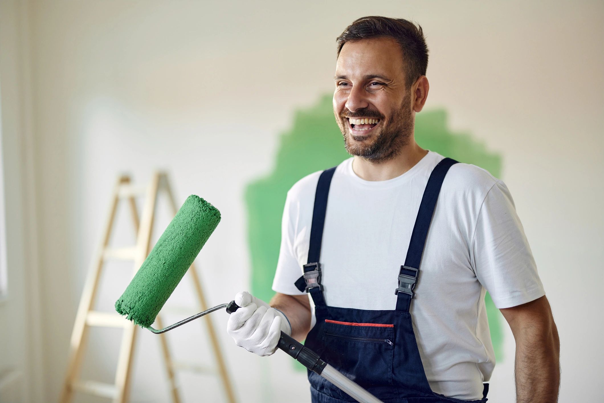 Painter applying green paint during renovation