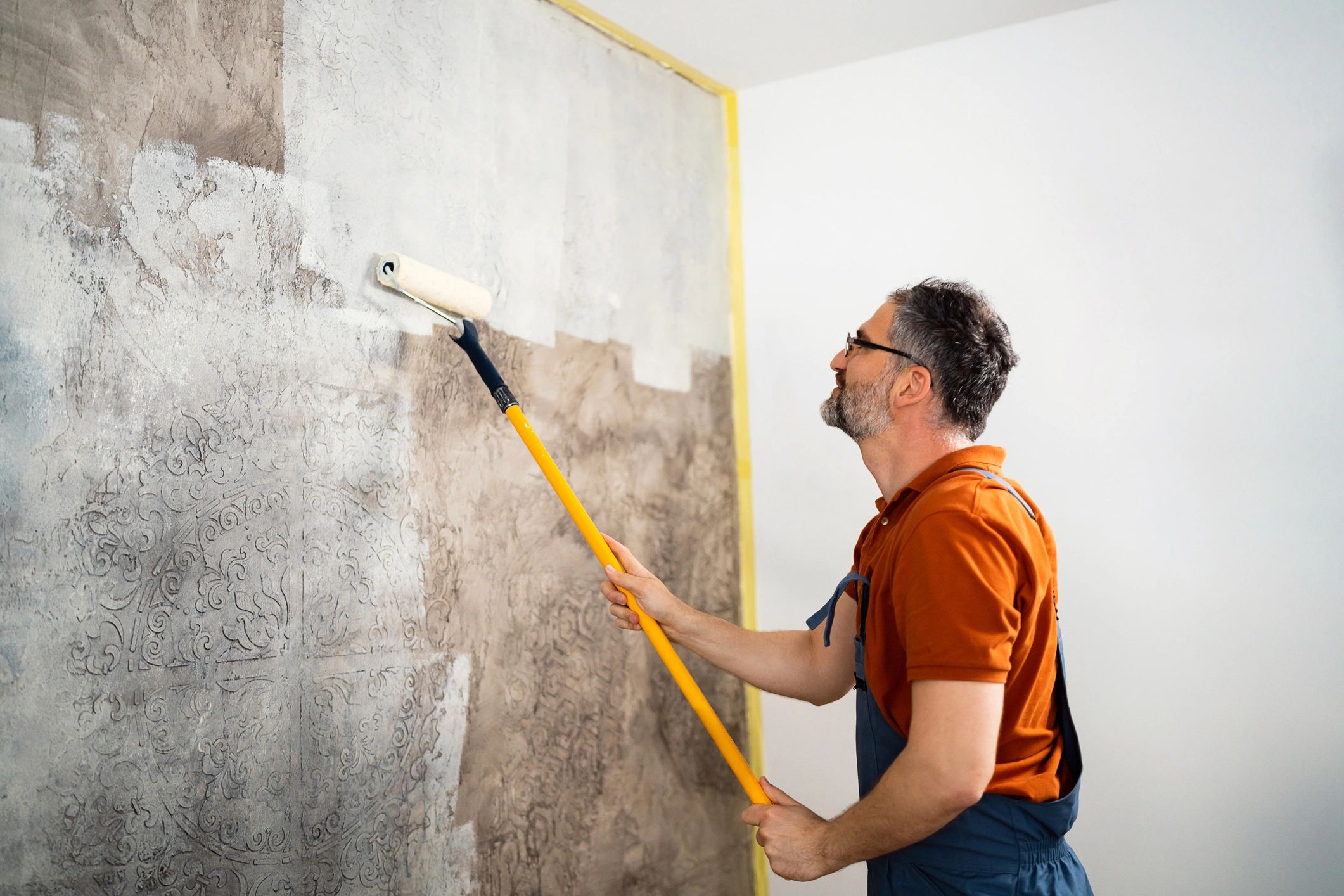 Professional painter rolling paint on an interior wall