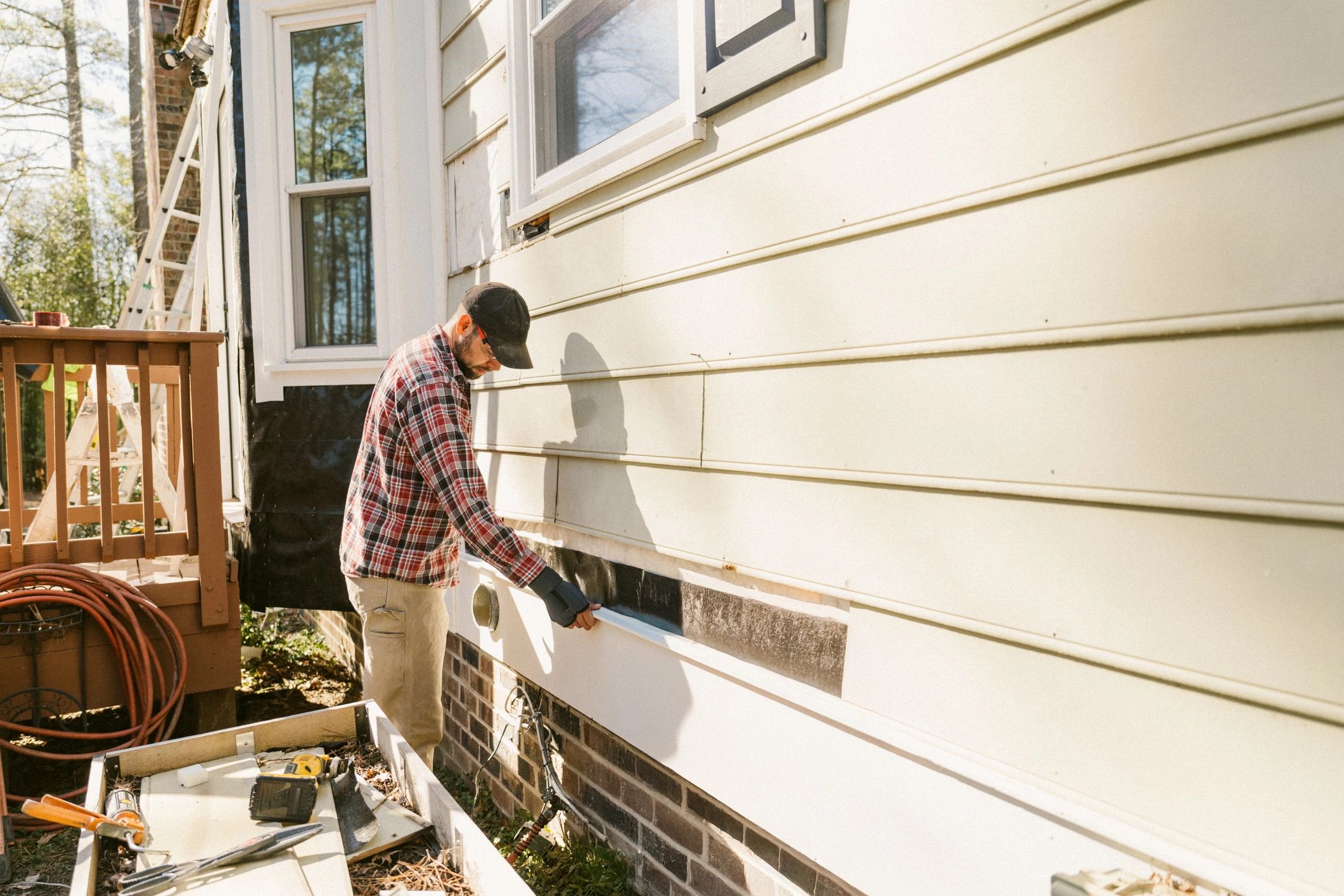 Worker repairing exterior house siding