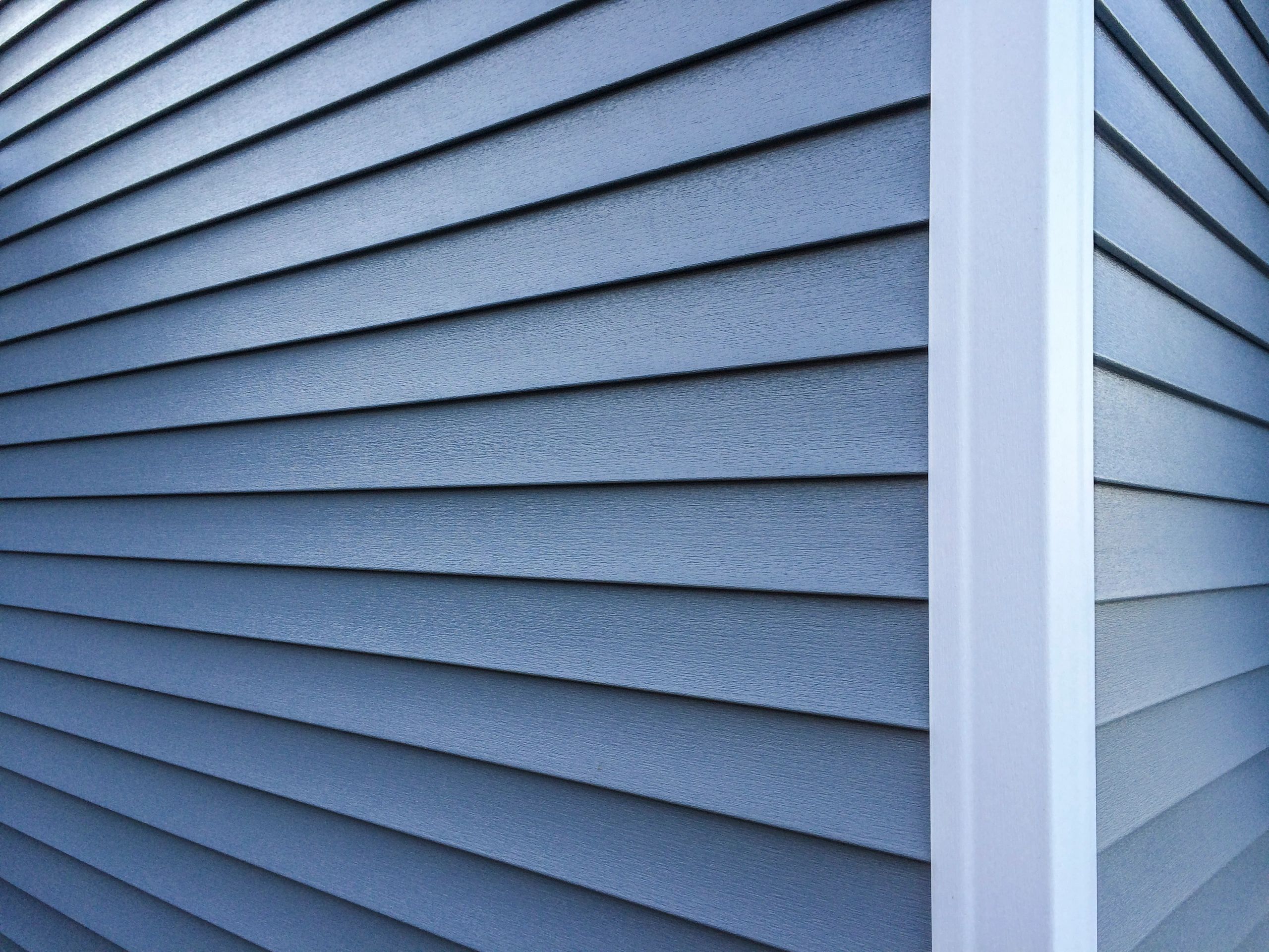 Close-up of new blue vinyl siding on a home